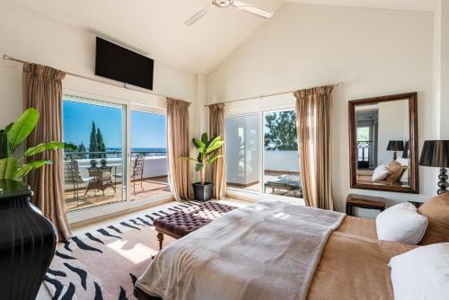 a bedroom with a bed and a view of the ocean at Palm Beach Frontline Penthouse in Marbella