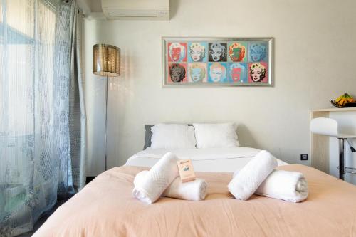 une chambre avec un lit avec deux oreillers blancs dans l'établissement Le Palm Beach - Croisette - Plage - Casino - Wifi, à Cannes