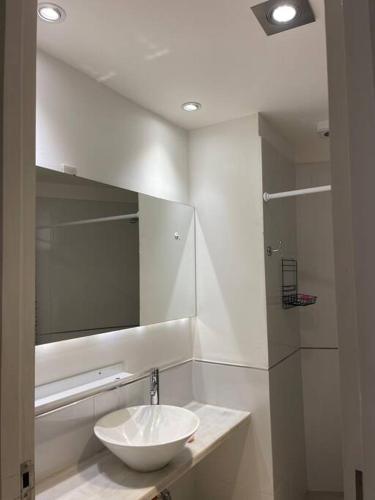 a bathroom with a white sink and a mirror at Monoambiente Seminario Suites in Yerba Buena