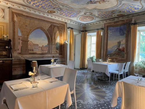 a restaurant with white tables and chairs and a painting at Agriturismo Podere La Piazza in Costigliole dʼAsti