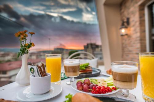a table with two glasses of beer and a plate of food at Simfonia Boutique Hotel in Râmnicu Vâlcea