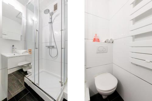 une salle de bain blanche avec douche et toilettes dans l'établissement Le Palm Beach - Croisette - Plage - Casino - Wifi, à Cannes