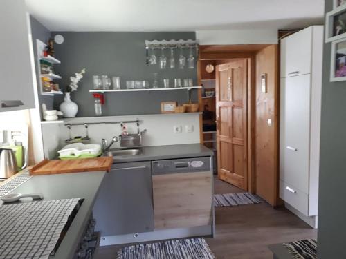 a small kitchen with a sink and a stove at Cottage Stela, family moutain hideout in Bohinj