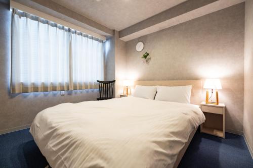 a bedroom with a large white bed and a window at RESIDENCE HARIMAYA in Kochi