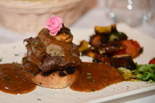 a plate of food with a pink rose on top at 5 Sunca in Kašina