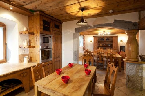 une cuisine et une salle à manger avec une table en bois dans l'établissement La ferme des Fontany, à Samoëns