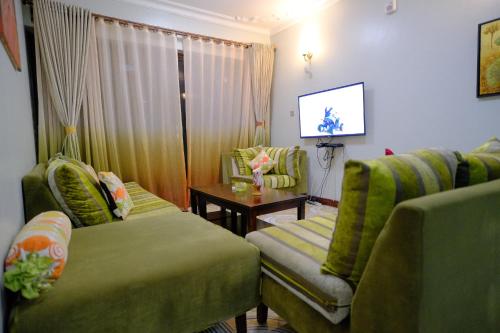 Uma televisão e/ou sistema de entretenimento em Crystal Apartments Entebbe Uganda Next to UN Base