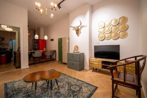 a living room with a television and a table and chairs at OIQIA • Tolosa in Toulouse