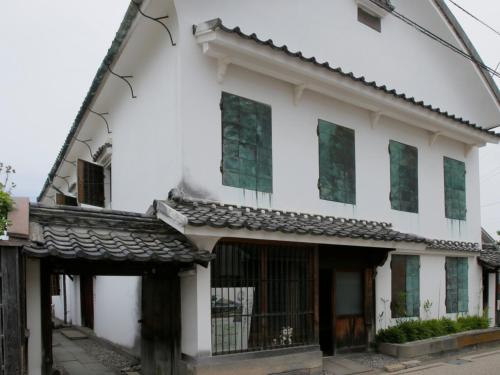 an old white house with green windows at Hotel New Otani Saga in Saga