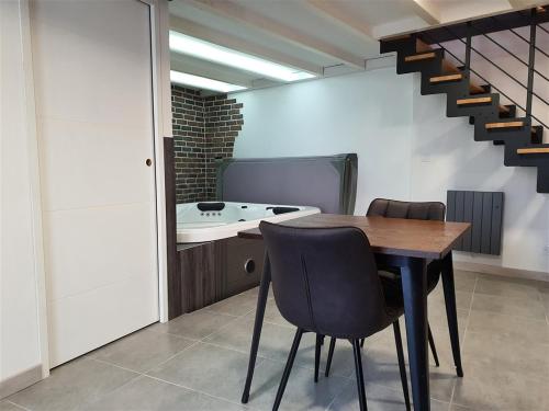 - une salle à manger avec une table, des chaises et un lavabo dans l'établissement Love room avec spa privatif, à Ruelle-sur-Touvre