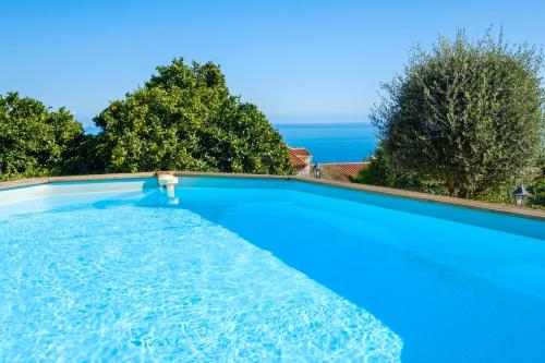 une grande piscine bleue avec l'océan en arrière-plan dans l'établissement Propriété Muraccioli 2 - Maison avec piscine vue mer, à Beausoleil