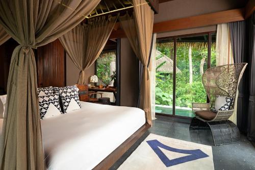 a bedroom with a bed and a large window at Keemala in Kamala Beach