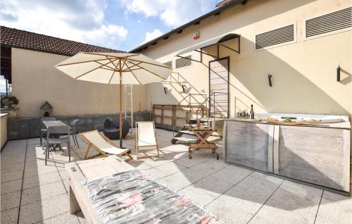 a patio with an umbrella and chairs and a table at Nice Apartment In Santo Stefano Belbo in Santo Stefano Belbo
