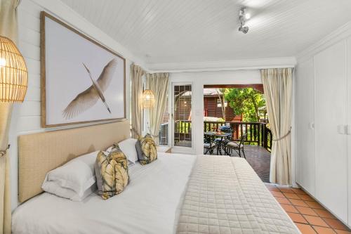 Un dormitorio con una cama blanca y un balcón. en Knysna - Happy Hollow Chalet, en Knysna