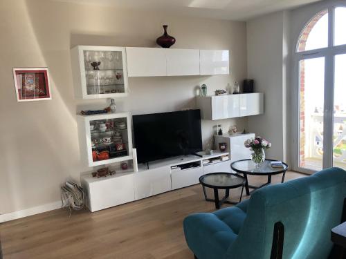 un salon avec une télévision, un canapé et une table dans l'établissement Rendez-vous avec la mer, à Hautot-sur-Mer