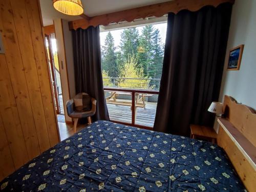 - une chambre avec un lit et une vue sur une terrasse dans l'établissement V du Bachat Joubarbe 1 6 pers, à Chamrousse