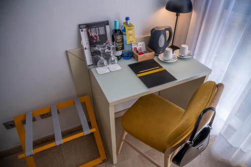 a small desk with a chair and a table with a lamp at Hotel SERHS Del Port in Barcelona