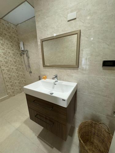 a bathroom with a white sink and a mirror at EM HOME Sukhumvit Bangkok - near Terminal 21, EM District Malls, BTS and MRT Lines in Bangkok