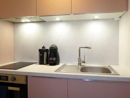 a kitchen with a sink and a counter top at Grand écran, piscine, beach-volley, pétanque inclus in Cucq