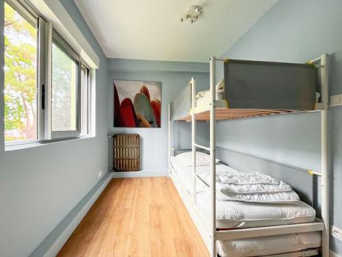 a room with two bunk beds and a window at Grand écran, piscine, beach-volley, pétanque inclus in Cucq