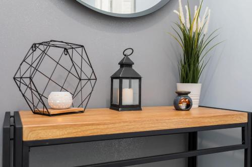 a table with a lantern and a candle on it at Rybacka 48 - Twoje miejsce wypoczynku, domki, studia, apartamenty, rowery, hulajnogi in Jantar