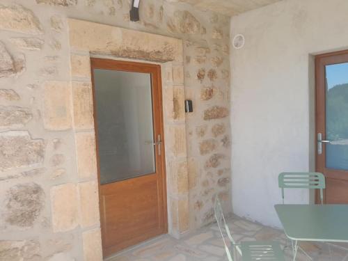 - un mur en pierre avec une porte en bois dans l'établissement Charmant appartement au calme, à Gilhoc sur Ormeze