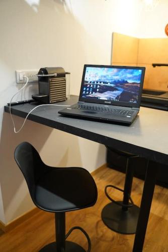 a laptop computer sitting on a desk with a chair at Au Refuge des amoureux avec baignoire Balnéo 2 personnes in Sélestat