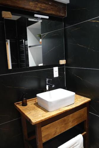 a bathroom with a white sink and a mirror at Au Refuge des amoureux avec baignoire Balnéo 2 personnes in Sélestat