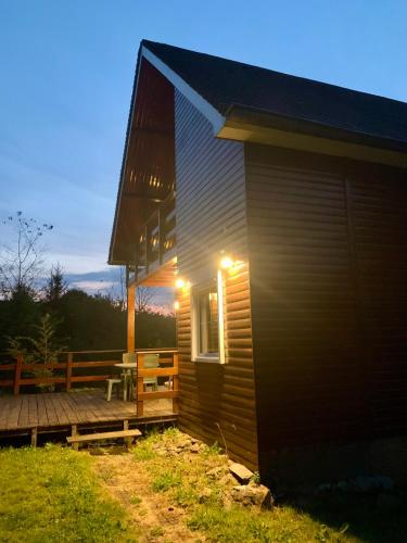 a house with a porch and a deck at Cosy Sjalay near the lake for 6-8 persons in Büchel