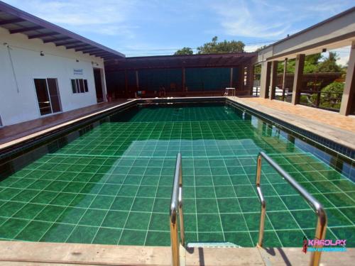 a swimming pool with a green floor in a house at Khaolak Dive Resort in Khao Lak