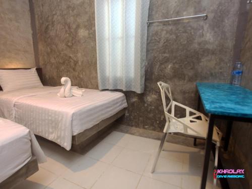 a room with two beds and a desk and a chair at Khaolak Dive Resort in Khao Lak