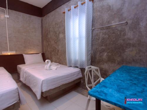 a bedroom with two beds and a blue table at Khaolak Dive Resort in Khao Lak