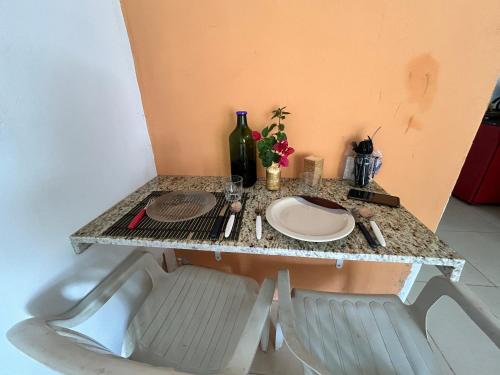 a table with a plate and a bottle of wine at Caminito Brasília Apto 02 in Luziânia