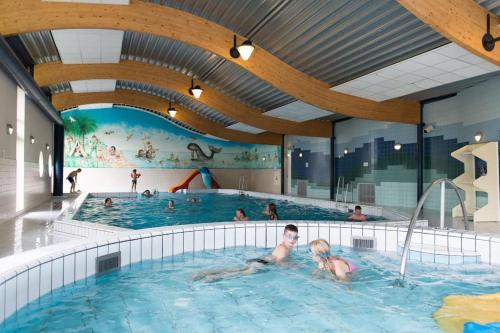 a group of people swimming in a swimming pool at Moderne chalet op het strand in Kropswolde