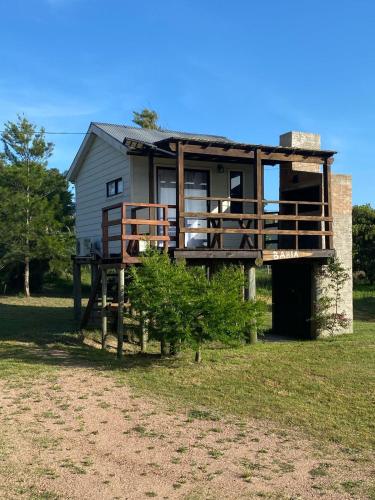 a house with a balcony on the side of it at Bahía in Punta Del Diablo