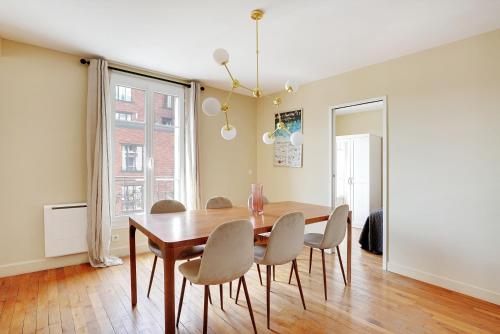 une salle à manger avec une table et des chaises en bois dans l'établissement Pick A Flat's Apartment in Saint-Ouen - Rue des Rosiers, à Saint-Ouen