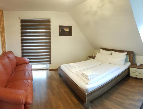a bedroom with a bed and a couch at Ferienwohnung Michelle mit Balkon für 1 - 6 Personen in Warmensteinach