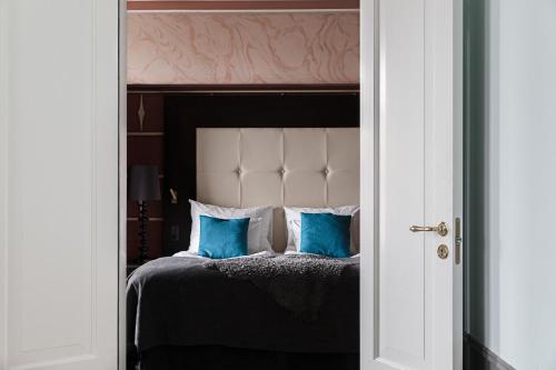 a bedroom with a bed with blue pillows at Clarion Hotel Wisby in Visby