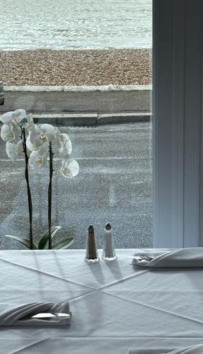 a table with a white table cloth and white flowers at Navigator Hotel in Bognor Regis