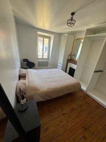 une chambre avec un grand lit et un parquet dans l'établissement Appartement de charme hyper centre, à Dijon