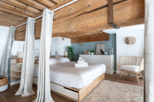 une chambre avec un lit à baldaquin et une chaise dans l'établissement MDOR - Atoll - Appt au cœur de Lyon, à Lyon