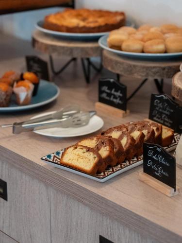 een bakkerij met brood en gebak op een toonbank bij Riva Toscana Golf Resort & SPA in Follonica