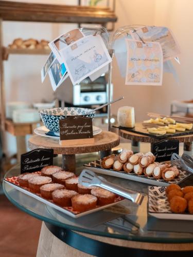een vitrine met verschillende soorten gebak en desserts bij Riva Toscana Golf Resort & SPA in Follonica