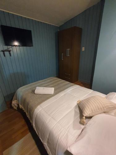 a bedroom with a large bed with two towels on it at Hostal El Baltico in Castro