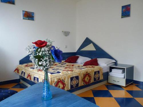 a bedroom with a bed with a vase of flowers on a table at Darling Hotel in Sofia