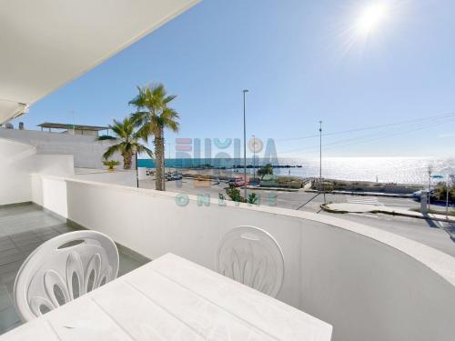 a view of the beach from the balcony of a building at Appartamento La Torre Fronte mare Primo Piano Puglia On line in Torre Mozza