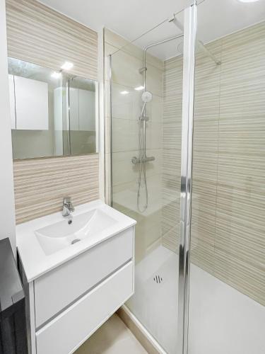 une salle de bain blanche avec un lavabo et une douche dans l'établissement Balcon Lumineux et Cuisine équipée, à Villeneuve-la-Garenne
