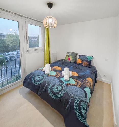 une chambre avec un lit avec une couette bleue dans l'établissement Balcon Lumineux et Cuisine équipée, à Villeneuve-la-Garenne