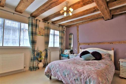 a bedroom with a large bed with a wooden ceiling at Tudor Cottage - hidden treasure in Tewkesbury