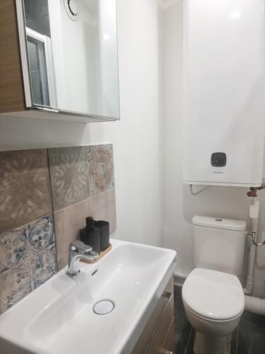une salle de bain avec un lavabo blanc et des toilettes dans l'établissement ExigeHome - Appartement en plein centre-ville, à Montigny-le-Bretonneux